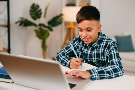 Happy boy student studying online using laptop