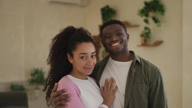 Portrait of young African American couple hugging at home, happy relationship