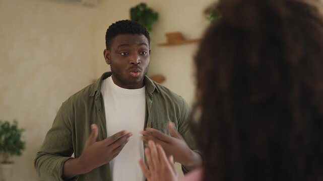 Upset African American man arguing with girlfriend at home, misunderstanding