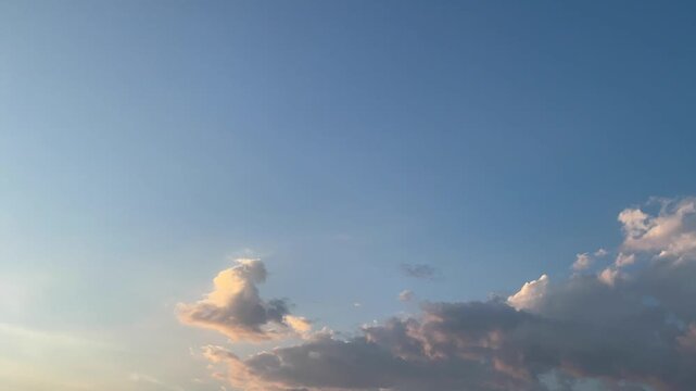 Clouds drifting across a blue sky at sunset