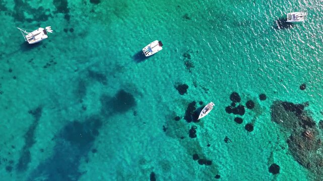 Aerial view of yachts anchored in turquoise water at Brandinchi beach, Sardinia