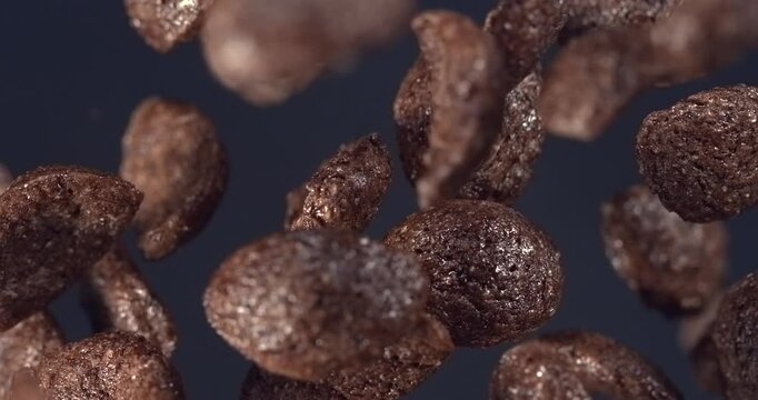 Chocolate cereal flakes falling in slow motion 1000 fps on dark background