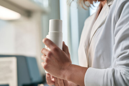 A close-up of a professional holding a skincare product, symbolizing product evaluation and emphasis on quality and innovation in the beauty industry.