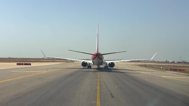 Immersive pilot eye view taxiing behind a twin-engine jet airplane ready for takeoff from Casablanca airport runway in a hazy summer day.