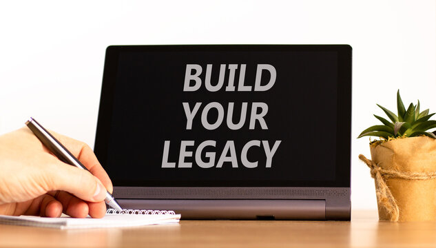 Build your legacy words symbol. Concept words Build your legacy on beautiful black tablet. Beautiful white background. Businessman hand. Business build your legacy concept. Copy space.