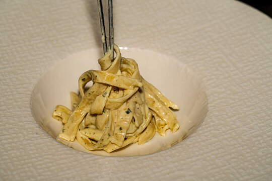 Classic Italian seafood pasta: hrimp fettuccine pasta served with creamy garlic sauce and fresh parsley on a plate.