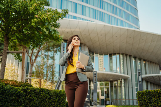 Businesswoman walking in city talking on smartphone