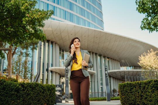 Businesswoman walking and talking on mobile phone