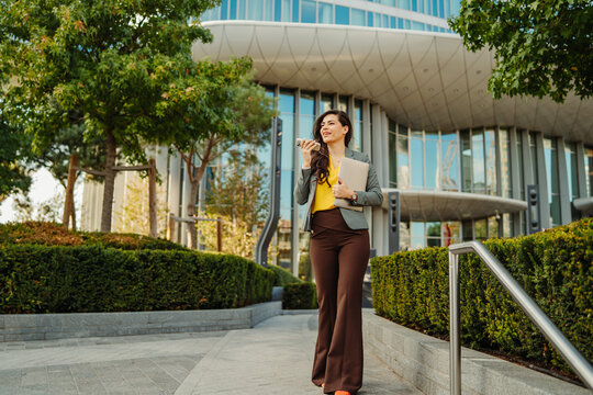 Businesswoman walking in city speaking on smartphone