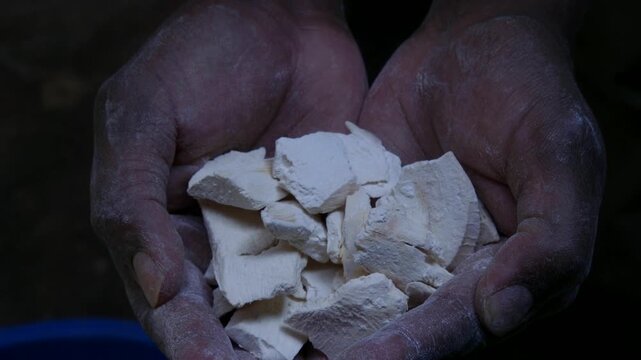 Hands holding pieces of dried cassava