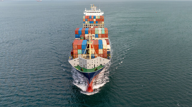 Front Aerial View of a Large Container Ship Sailing Open Sea, Cargo Vessel Loaded with Shipping Containers. International Logistics