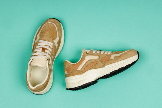 Pair of casual shoes on green background. Women's sports shoes.