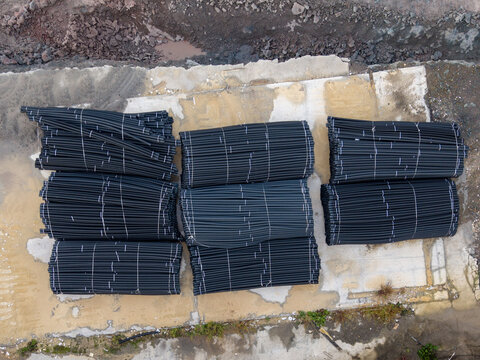 Aerial view of organized bundles of black plastic pipes stacked on a concrete construction site in Istanbul, Istanbul, Turkiye.