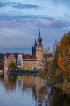 Fall landscape view of Novotneho lavka - Smetanovo  embankment (Smetanovo nabrezi) with historic architecture and autumn trees under a cloudy sky. Prague, Czech Republic 