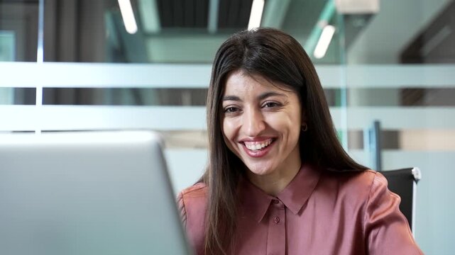 Close-up of happy businesswoman reading good news on laptop in office. Excited female celebrating success and feeling joy after receiving a positive message, happiness and satisfaction at workplace.