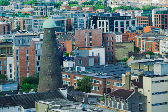 View of the historic St. Patrick's Tower surrounded by a mix of modern apartment buildings and traditional brick architecture in the urban landscape of Dublin, County Dublin, Ireland.