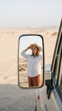 Woman in a Sun Hat Reflected in a Side Mirror