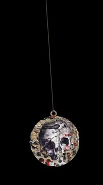 An animated Halloween themed hanging element in a paper-collage style that gently sways on a loop and features spooky ephemera details.
