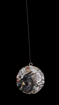 An animated Halloween themed hanging element in a paper-collage style that gently sways on a loop and features spooky ephemera details.
