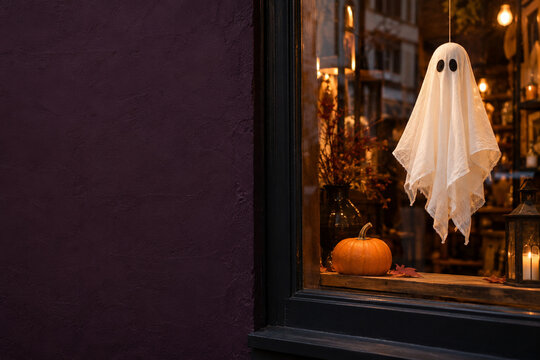 White cloth ghost hanging in a Halloween shop window