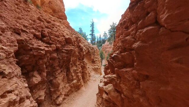 View of the narrow trail winding through the iconic orange hoodoos and sedimentary rock formations of Bryce Canyon, Utah, United States.