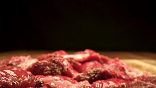 4K Video of fresh beef strips arranged on a dark surface, showcasing the rich red color and texture of raw meat.