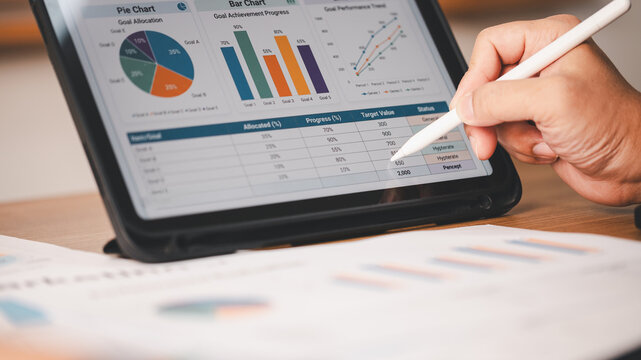 Close-up person pointing stylus pen digital tablet financial data charts graphs report. Concept business analysis corporate strategy investment planning market statistics performance success
