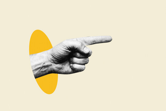 Human hand pointing index finger sideways out of yellow oval hole