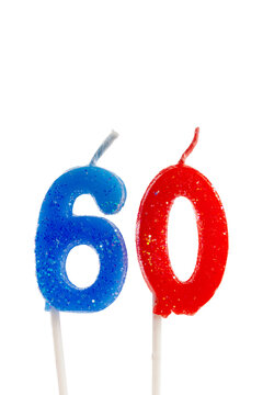 Blue and red number candles shaped as six and zero stand on white sticks