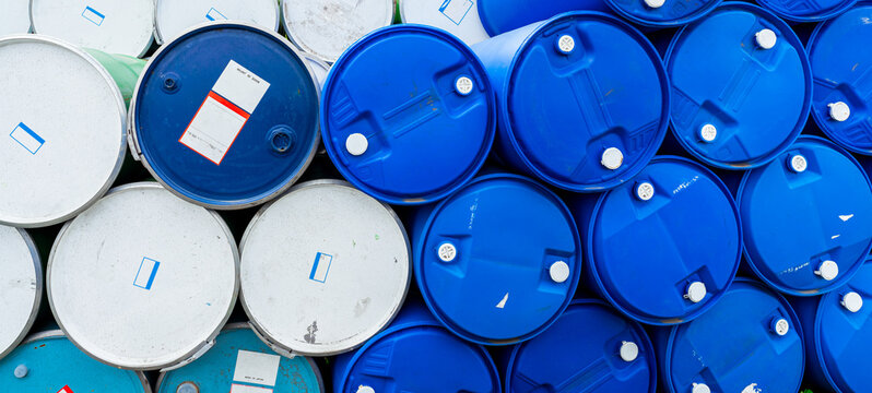 Chemical barrels stacked at an industrial warehouse, plastic and steel drums used for hazardous material, chemical storage, toxic waste handling and factory safety. Hazardous waste management.