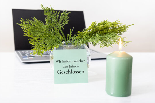 Zwischen den Jahren geschlossen: Ank&uuml;ndigung f&uuml;r Betriebsferien in der Weihnachtszeit mit dezenter Weihnachtsdekoration und Laptop