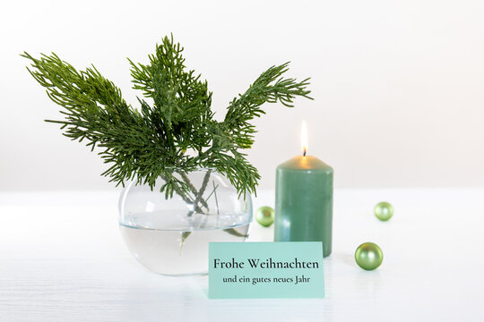 Weihnachtsgr&uuml;&szlig;e und Silvestergr&uuml;&szlig;e in dezentem Stil mit Gru&szlig;karte, Tannenzweigen, Kerze und Christbaumkugeln