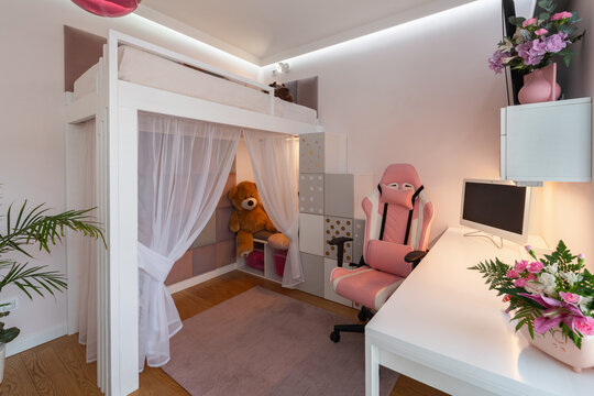 Kids room interior features white wooden loft bed with curtain play tent, giant teddy bear, pink ergonomic chair, study desk, and storage steps.