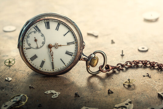 Antique clock on the table among the scattered parts of the clockwork. Conceptual macro background on the theme of time, antiques, history, service, repair . Old watch and gear.