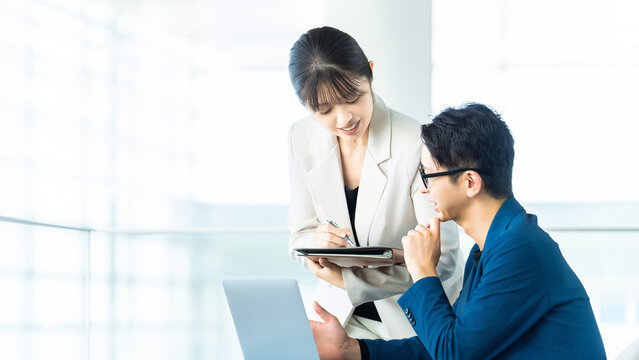 打ち合わせをする男女2人のビジネスマン