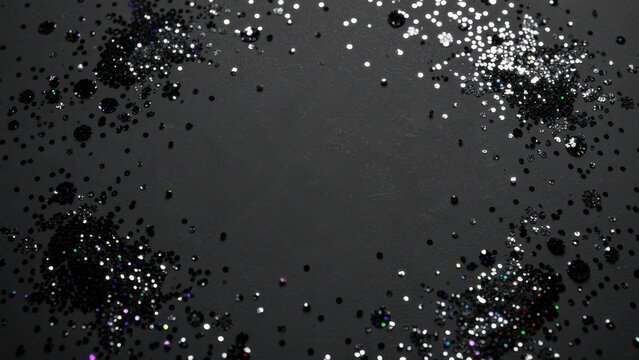 elegant matte black background scattered with iridescent glitter and confetti for sophisticated luxury marketing backdrop