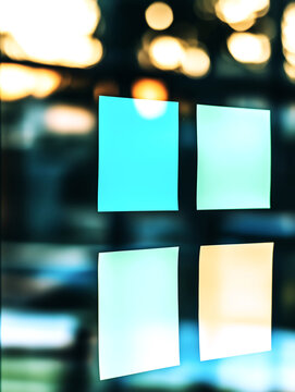 Four Blank Colorful Sticky Notes on Glass with Blurred Lights
