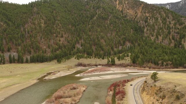 Aerial view of winding river and forested mountain landscape