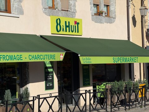 menthon saint-bernard, France - may 20 2026: An 8 a Huit grocery store building with bright green awnings showing Fromage Charcuterie and Supermarket.