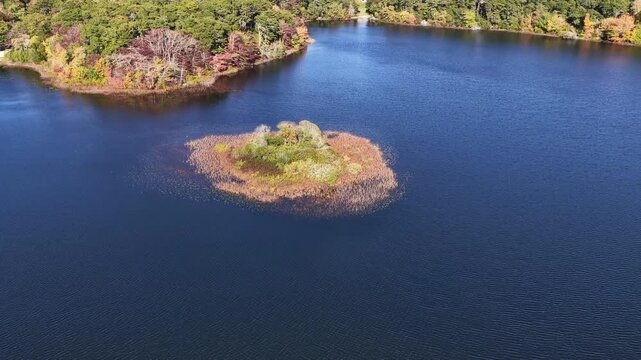 Colorful autumn foliage is found fringing Pilgrim Lake in Orleans, Massachusetts. This scenic destination is on the outer part of Cape Cod, not far from the Atlantic Ocean.