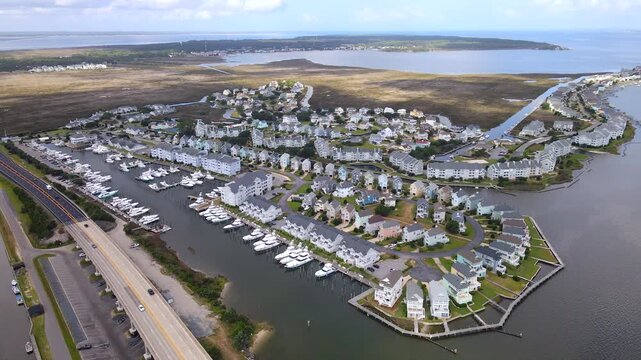 A coastal neighborhood fills the view between yacht berths and narrow residential canals.