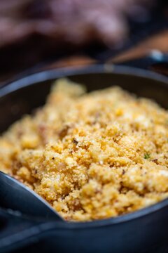 View of farofa, a traditional Brazilian toasted cassava flour dish served in a black cast iron skillet, with crispy texture and golden color in Rio de Janeiro, Rio de Janeiro, Brazil.