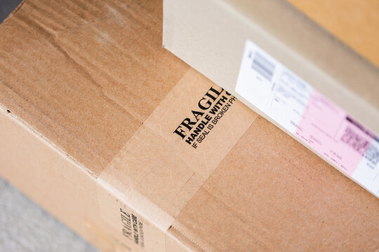 Cardboard boxes with fragile on tape by door of house from online home delivery orders