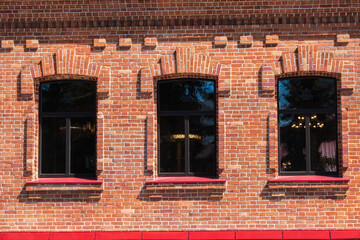 Three windows of the old mansion 19 century with brown bricks wall © Dmitrii Potashkin