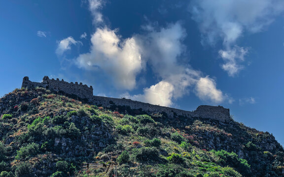 Dramatic travel photograph showcasing the ancient Saracen castle perched atop Monte Tauro in Taormina, ideal for Sicilian heritage guidebooks, travel publications, and tourism media.