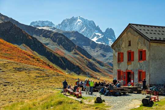 Col de Balme, France/Switzerland - 18.09.2025: Hikers resting at the mountain refuge with views of the snow-capped Mont Blanc massif.