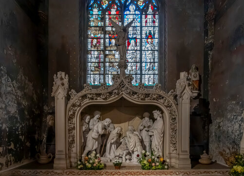 Verneuil-sur-Avre, France - 10 09 2026: Church of the Madeleine. Detail view of the nativity statue and a stained-glass window above