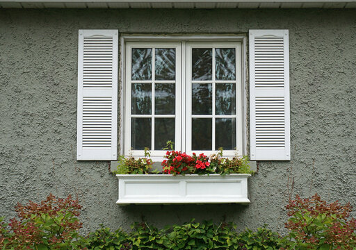 stucco house and window with shutters and box for flowers