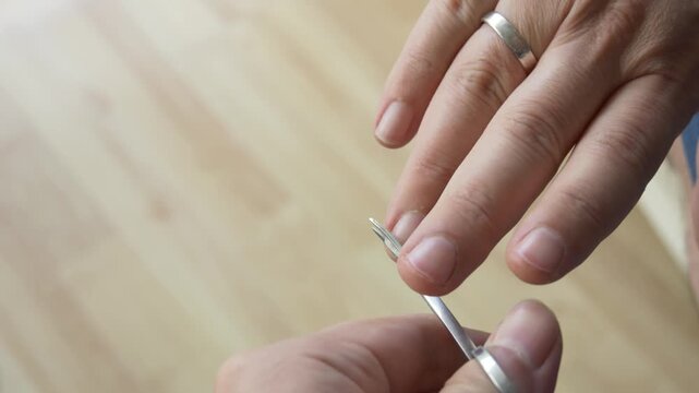 Man Performing Home Manicure with Nail Scissors