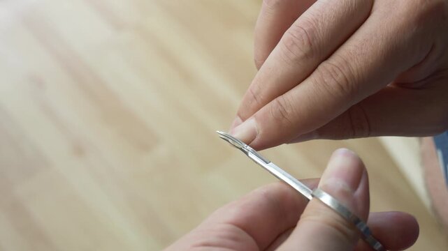 Man Cutting Fingernails with Manicure Scissors